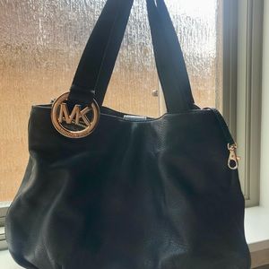 Black leather Michael Kors shoulder bag w/ gold MK logo. Dust bag included.